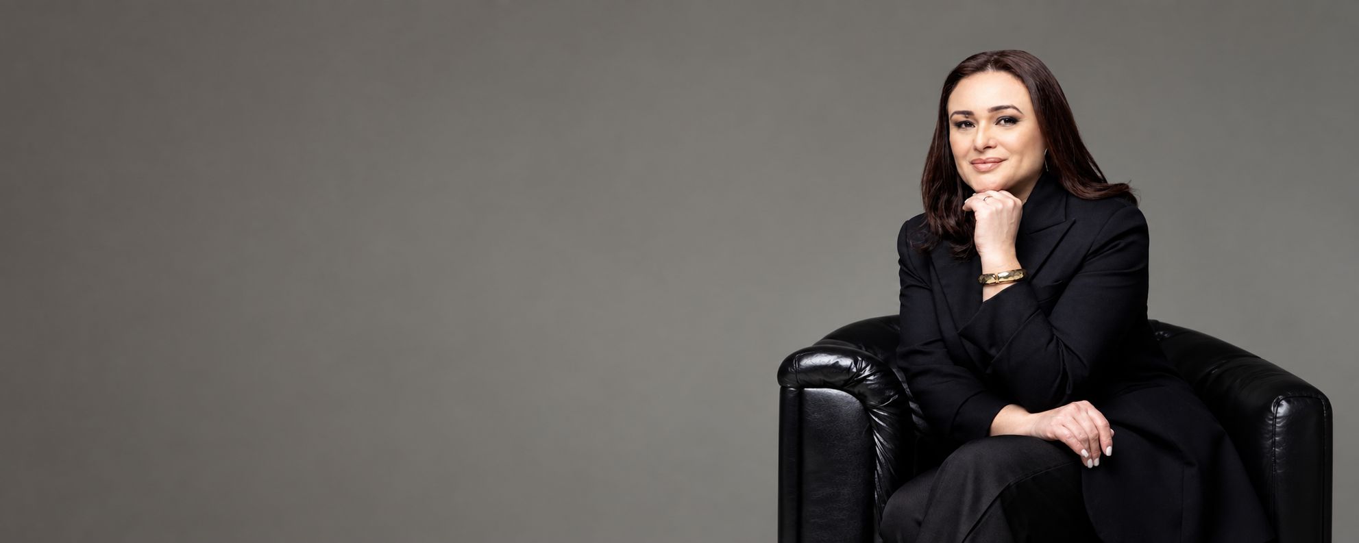 Dra. Charlene Welter, advogada em Joinville, de blazer preto em poltrona de couro